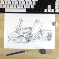 a drawing of a sports car is on the desk next to a keyboard and mouse