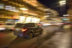 a blurry photo of cars driving down the street at night in an urban area