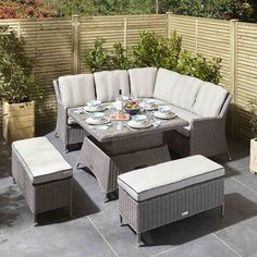 an outdoor dining set with white cushions