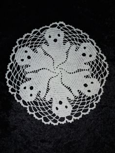 a white doily on a black background