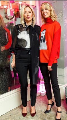 two women standing next to each other in front of a store window with mannequins