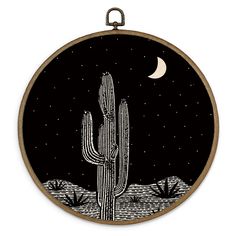 a black and white image of a cactus with the moon in the background