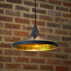 a light fixture hanging from a brick wall