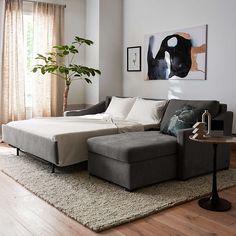 a living room filled with furniture and a large painting hanging on the wall above it