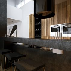 a modern kitchen with black counter tops and stainless steel appliance on the wall