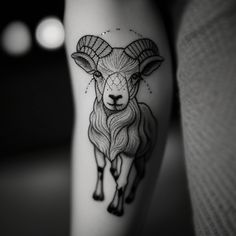 a black and white photo of a goat tattoo on the leg, with stars in the background