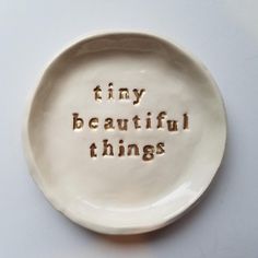 a white plate with the words tiny, beautiful things written in small letters on it