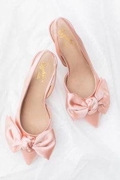 An understated heel with a slingback means you won’t be slipping these off when it comes time to dance. Plus that satin bow? Perfect. | Photo: @stephh.walker Satin Low Heel Heels With Bow, Spring Wedding Shoes In Satin With Pointed Toe, Spring Wedding Shoes With Bow And Block Heel, Chic Bow Slingback Pumps For Wedding, Low Heel Heels With Satin Bow For Spring, Spring Low Heel Heels With Satin Bow, Spring Low Heel With Satin Bow, Feminine Satin Pointed Toe Heels, Feminine Low Heel Slingback Pumps For Wedding