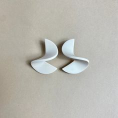 three pieces of white ceramic sitting on top of a table