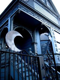 an ornate building with wrought iron railings and a crescent on the door