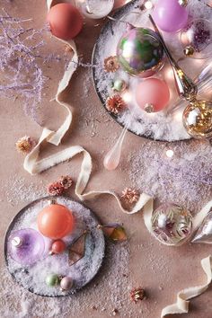 two plates filled with different types of ornaments on top of snow covered ground next to confetti cones