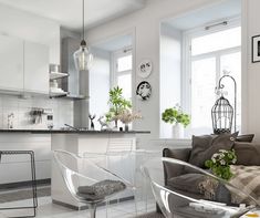 a living room filled with furniture next to a kitchen and dining room table in front of a window