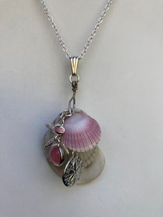 "Natural sea shell pendant necklace, ocean shells clustered with all different types of shells, with a Starfish and Sand dollar charms on a Sterling plated 20\" loop chain and Sterling bail. Unique seashell pendant measures 2 3/4\" X 1 1/4'' You can compare the size of the shells to the $0.50 cent piece in the pictures. All my necklaces are different and would be considered one of a kind. View my collection of Kingman Arizona Turquoise here: https://www.etsy.com/shop/MoonwaterJewelryShop?section_id=28192591  I've been selling on eBay since 2003 Came to Etsy to sell jewelry. Returns and exchange details ► RETURNS / EXCHANGES All items are handcrafted and custom pieces therefore we don't usually accept returns or exchanges on jewelry unless the fault was ours. Screens do not always reflect t Ocean-inspired Charms For Jewelry Making, Starfish Charm Shell Necklace As A Gift, Starfish Charm Shell Necklace Gift, Starfish Shell Necklace As Gift, Starfish Charm Shell Necklace For Gift, Starfish Shell Necklace Perfect For Gifts, Starfish Shell Necklace For Gift, Pink Starfish Charm Jewelry, Silver Shell Pendant Jewelry