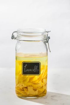 a glass jar filled with yellow flowers on top of a table