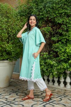 Dusty jade kurtapant set is perfect for a festive season or a day out .Cotton cambric fabric makes it perfect for summer weather. Front v-neckline kurta with lace detail bell sleeves give a classic look. Product has no lining. Pant has two side pockets, back elasted waistband and lace on the hem. Cold wash and Dry clean only.Type of Work: Solid Fit: Loose Model Height: 5'7 Measurements: Kurta-36.5" Pant- 34" SKU#: 11702071GR Disclaimer: There may be slight difference in actual product color comp Bohemian Cotton V-neck Sets, Green Cotton V-neck Set, Festive Cotton V-neck Kurta, Cotton V-neck Kurta With Chikankari Embroidery, Festive Cotton V-neck Kaftan, Cotton Lace Trim Sets With Short Sleeves, Cotton Sets With Lace Trim And Short Sleeves, Summer V-neck Chikankari Kurta, Cotton Short Sleeve Sets With Lace Trim