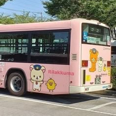 a pink bus is parked on the side of the road in front of some trees