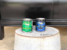 two cans of beer sitting on top of a table