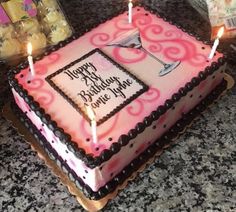 a pink and black birthday cake with candles