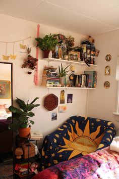 a bed room with a neatly made bed and lots of plants on the shelves above it