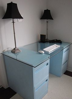 a desk with a keyboard and two lamps