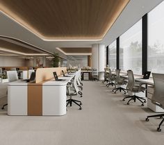 an office with many desks and chairs in the middle of it, along with large windows