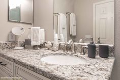 a bathroom with marble counter tops and white towels