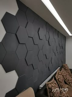 a room with black and white hexagonal tiles on the wall next to a couch