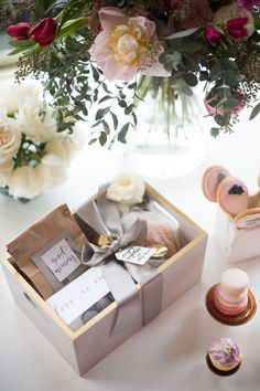 a bouquet of flowers sitting on top of a table next to a box filled with items