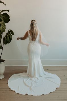 a woman in a wedding dress is standing on the floor with her back to the camera