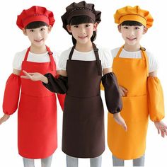 three children wearing aprons and hats standing next to each other