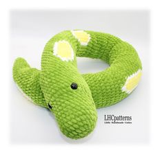 a green stuffed snake with white spots on it's head