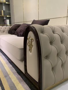 a white couch sitting on top of a carpet covered floor next to a book shelf