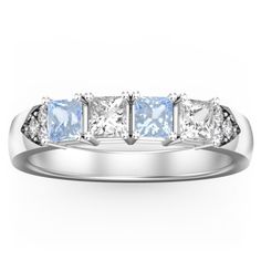 a white gold ring with three princess cut diamonds on the side and four baguetts in