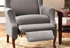 a gray recliner chair sitting on top of a rug