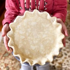 a person holding a pie crust in their hands