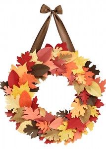 an autumn wreath with leaves hanging from it's front loop and a bow on the top