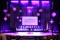 the stage is lit up with purple lights and snowflakes