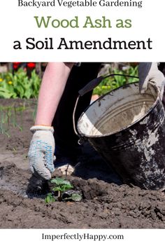 a person is digging in the dirt with a bucket and gardening gloves on their hands