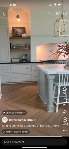 a kitchen with white cabinets and an island in the center, surrounded by wooden floors