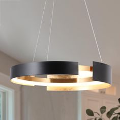 a black and gold circular chandelier hanging from a ceiling in a living room