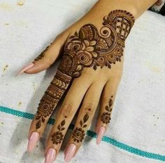 a woman's hand with henna tattoos on it