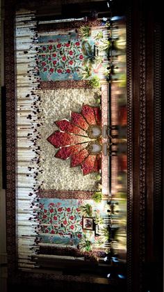 a quilted table runner with red and green leaves on it in front of a window