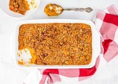 a casserole dish with granola on top and two plates next to it