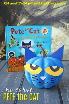 a pumpkin with a cat face painted on it and a book about pete the cat