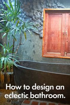 a bath tub sitting in front of a wooden door next to a potted plant