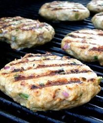 hamburger patties cooking on an outdoor grill