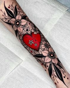 a woman's arm with flowers and a heart on it