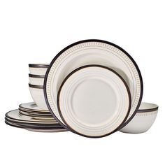 a stack of white and black dinner plates on top of each other with brown trimmings