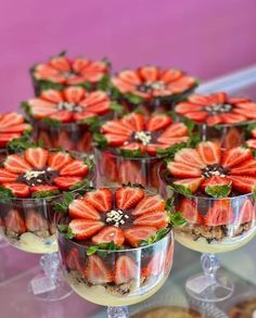 desserts with strawberries and chocolate are arranged on display