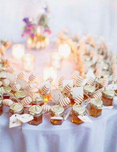 honey jars and candles are arranged on a table